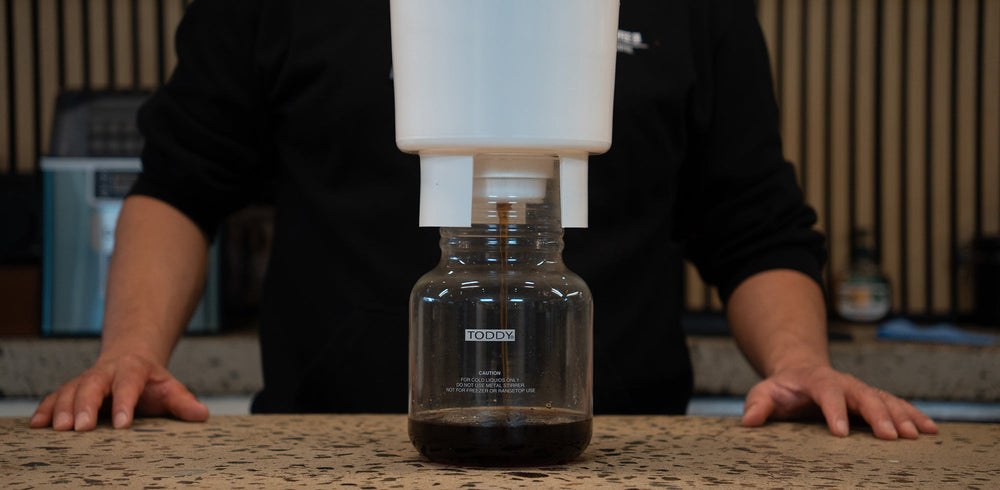 Toddy cold brew maker draining concentrate into a glass decanter